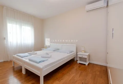 Svjetla spavaća soba sa dva kreveta i drvenim podom. - image 17
