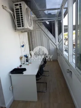 Enclosed balcony with a desk and chairs. - image 15