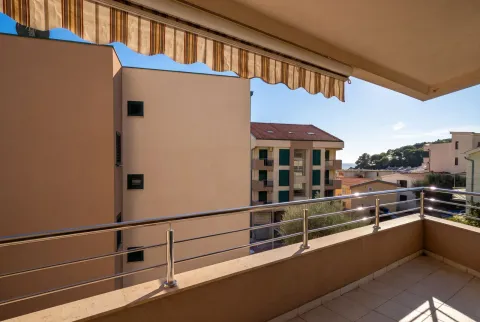 Spacious covered terrace with metal railing and view of surrounding buildings and neighborhood. - image 4