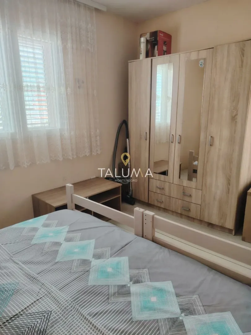 Furnished bedroom with a large wardrobe and a window.
