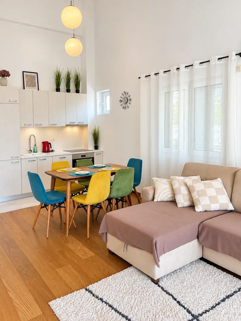 Bright living room with a dining area and built-in kitchen in an open-plan space.