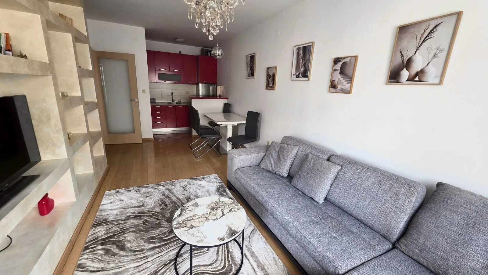 Living room with sofa, coffee table and view of the dining area and kitchen.