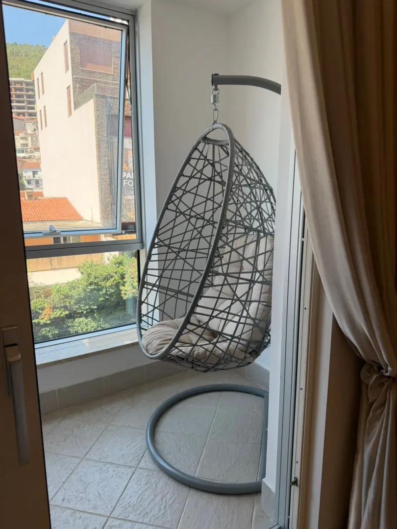 Natkriveni balkon sa visećom foteljom i pogledom na grad.