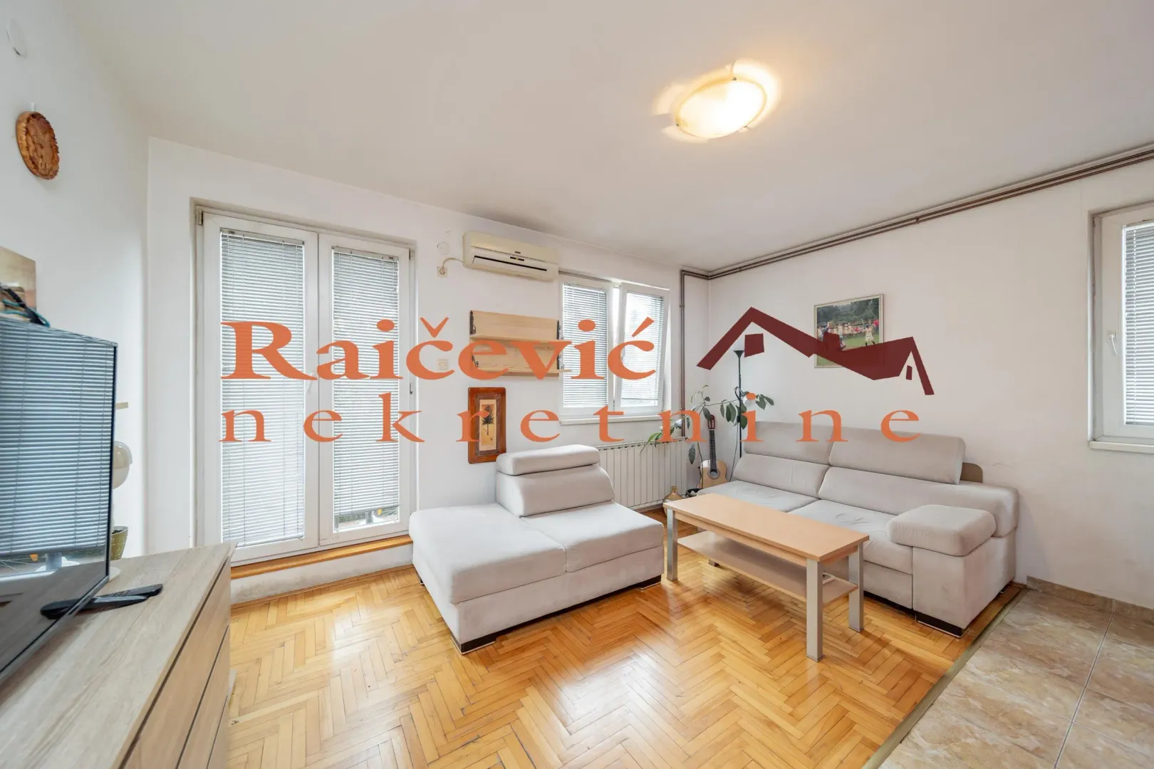 Living room with a seating set and wooden parquet flooring.