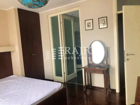 Furnished bedroom with a double bed, wardrobe, and a wooden dressing table. - image 19