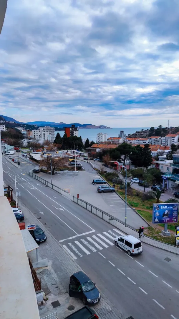 View from the terrace overlooking the city street and the sea in the distance.