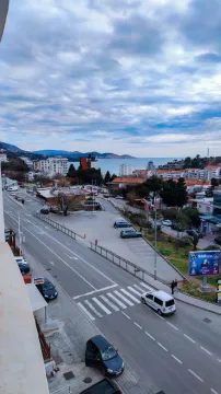 View from the terrace overlooking the city street and the sea in the distance. - image 8