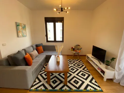 Uređena dnevna soba sa ugaonom garniturom, stočićem i televizorom. - image 2