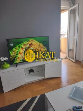 Dnevna soba sa TV komodom i izlazom na terasu. - image 3