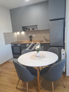 Small kitchen with a dining table and grey cabinets. - image 3