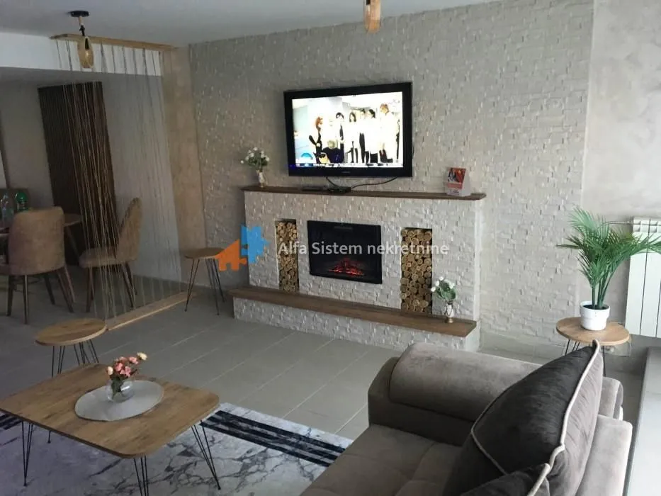 Living room with a fireplace, television, and seating set.