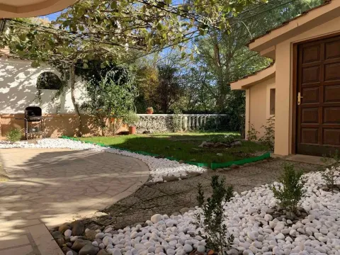Landscaped yard with paved pathways, decorative stones, and a barbecue grill. - image 11