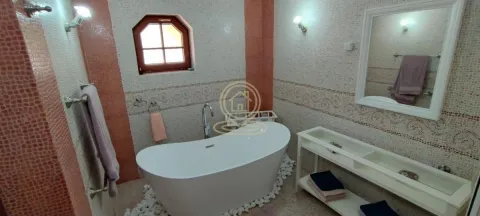 Bathroom with a freestanding bathtub, washbasin, and decorative mosaic tiles. - image 15