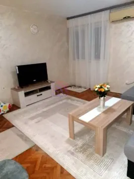 Living room with sofa, coffee table and television. - image 9