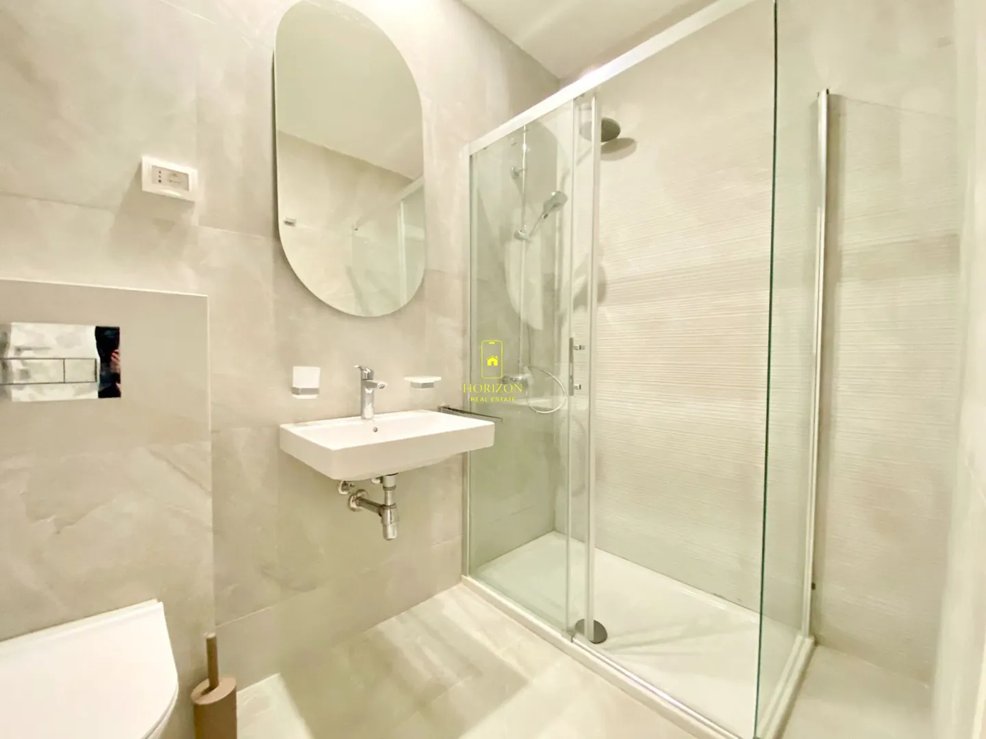 Modernly equipped bathroom with a shower cabin and a washbasin.