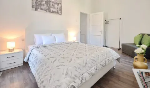 Prostrana spavaća soba sa bračnim krevetom, noćnim stočićima i sofom. - image 11