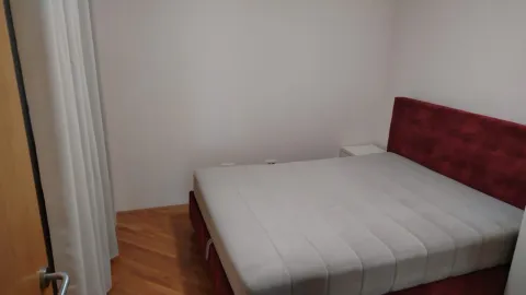 Spavaća soba sa bračnim krevetom i drvenim podom. - image 4