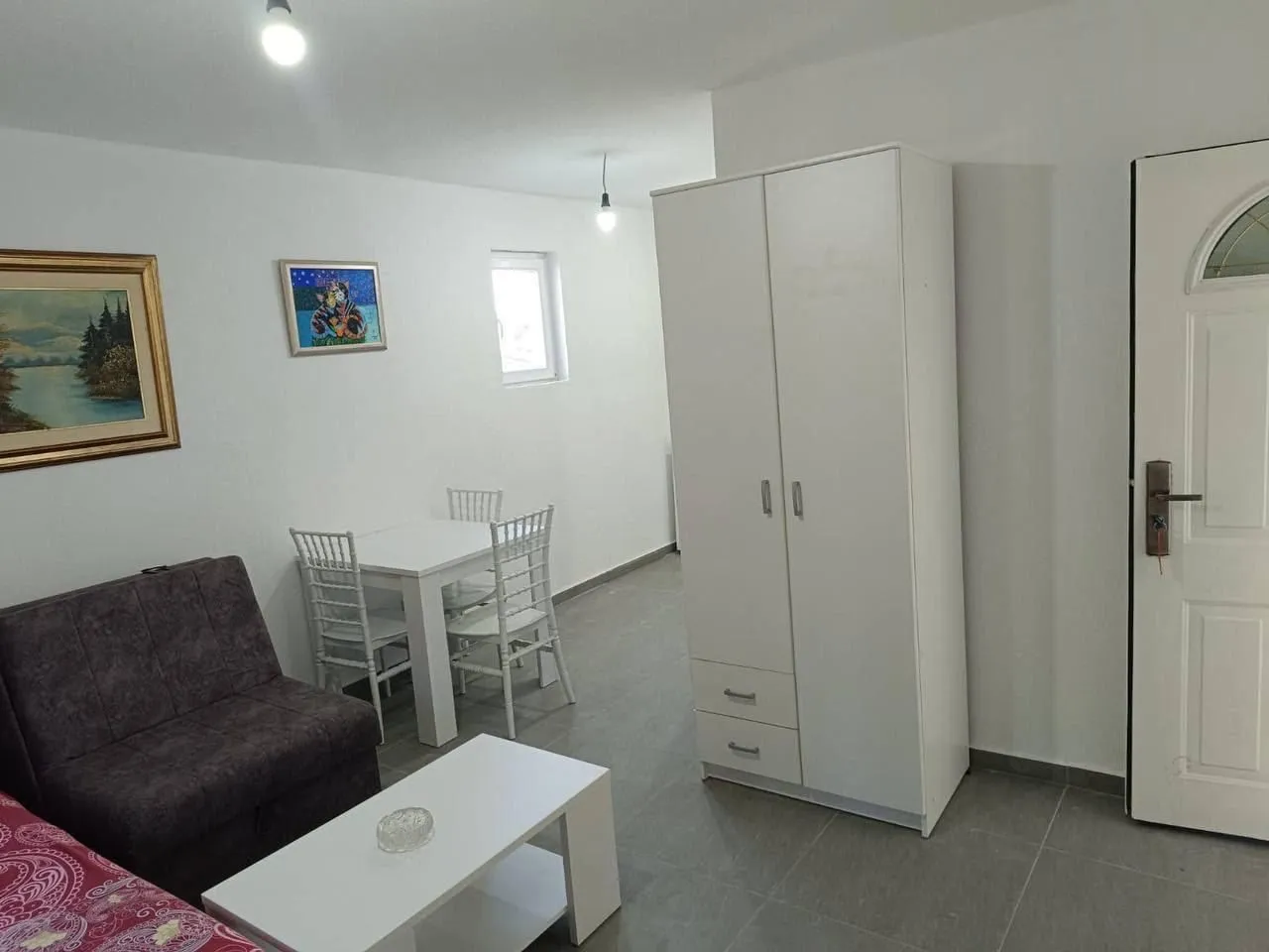 Living room with sofa, dining table and wardrobe.