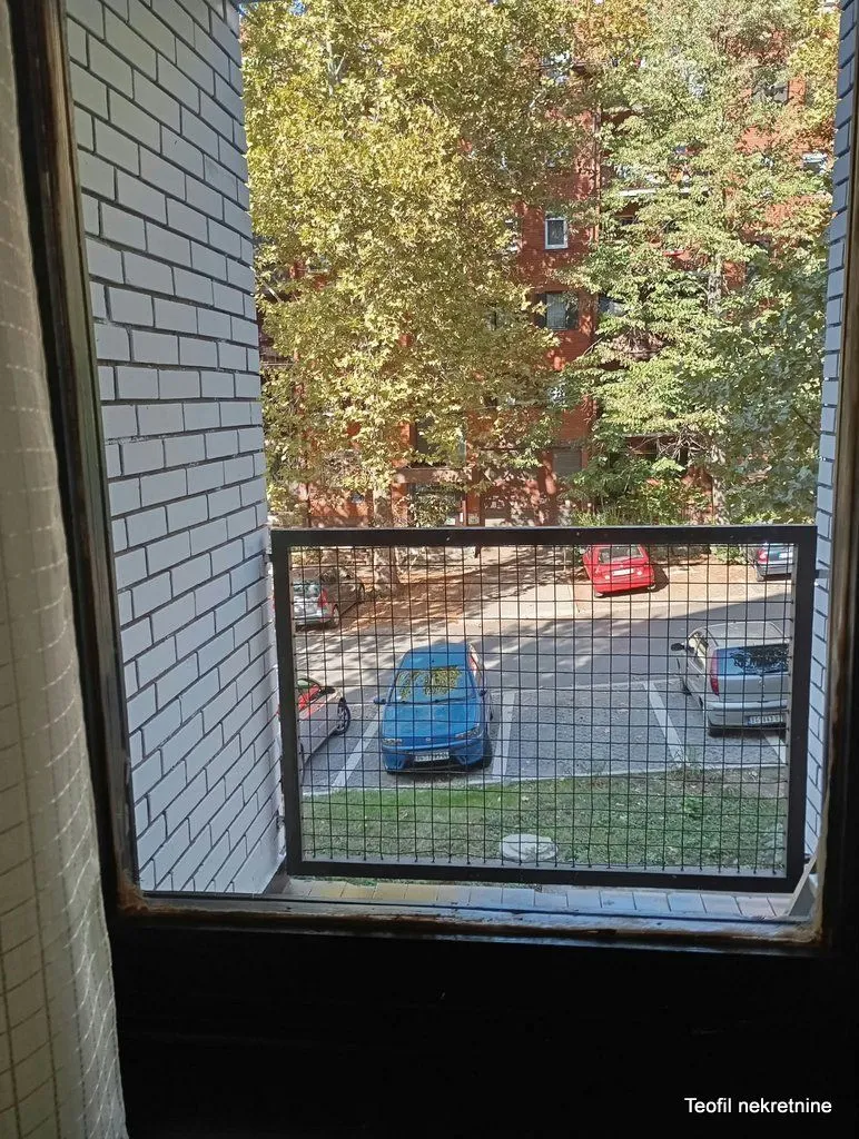 View from the balcony overlooking the parking lot and surrounding greenery.