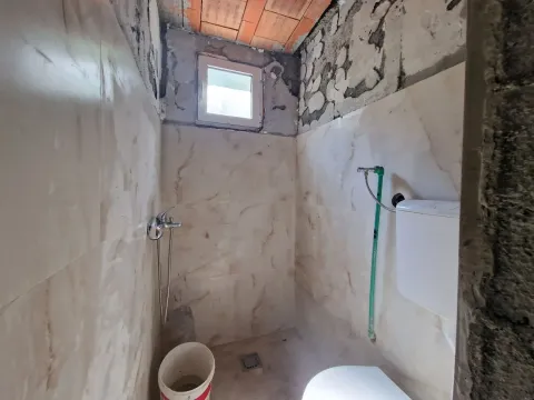 Kupatilo u fazi renoviranja sa postavljenim pločicama i sanitarijama. - image 18