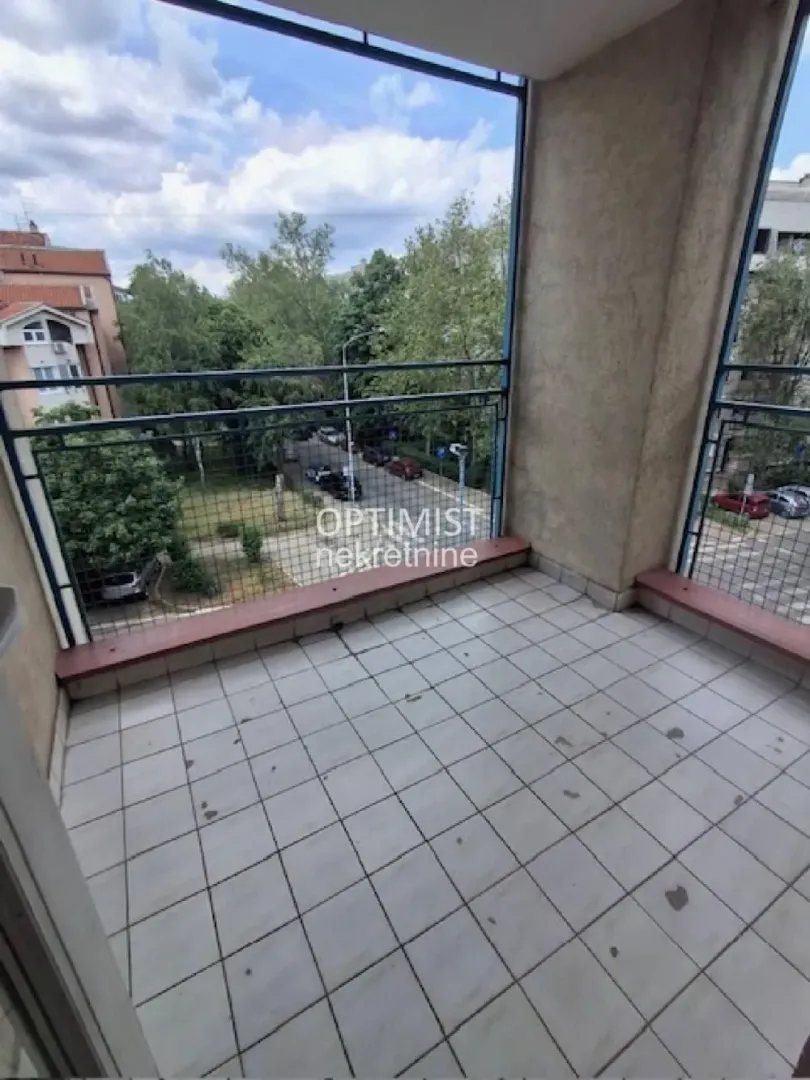Natkrivena terasa sa keramičkim pločicama i pogledom na ulicu.