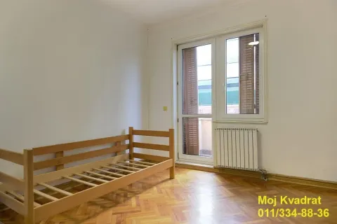 Prazna soba sa drvenim krevetom i izlazom na terasu. - image 8