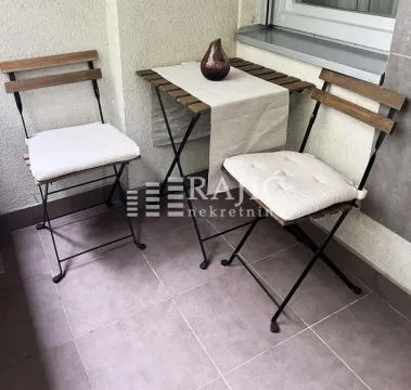 Small furnished balcony with a table and two chairs. - image 14