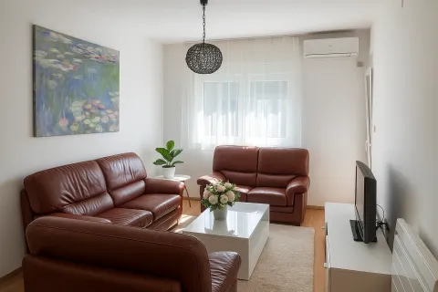 Living room furnished with leather sofas, a coffee table, and a television. - image 7