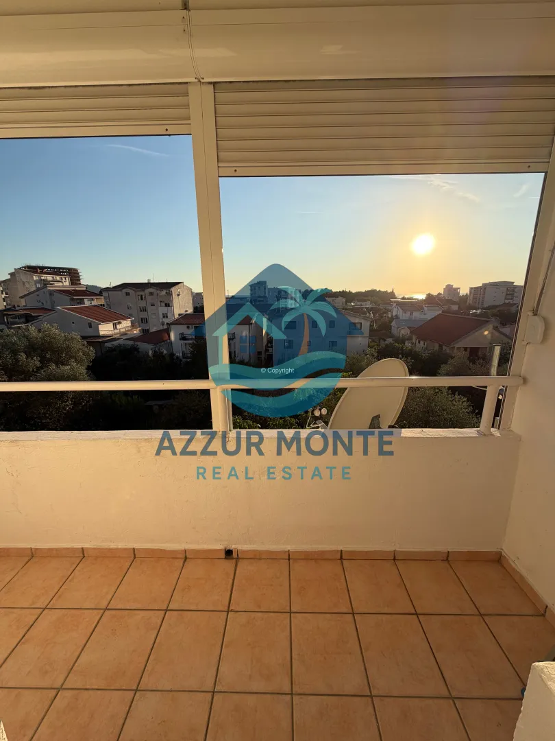 Enclosed terrace with a view of the neighborhood and sunset.