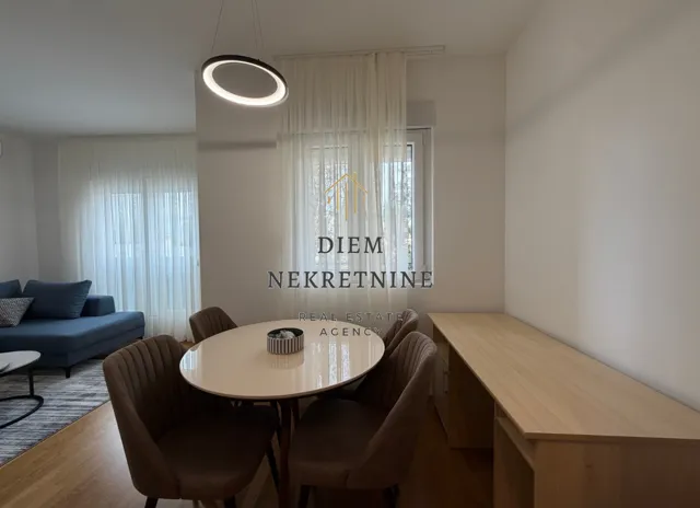 Dnevni boravak sa trpezarijskim stolom i stolicama.