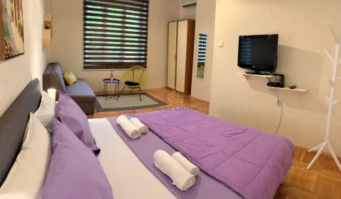 Prostrana spavaća soba sa bračnim krevetom, sofom i TV-om. - image 2