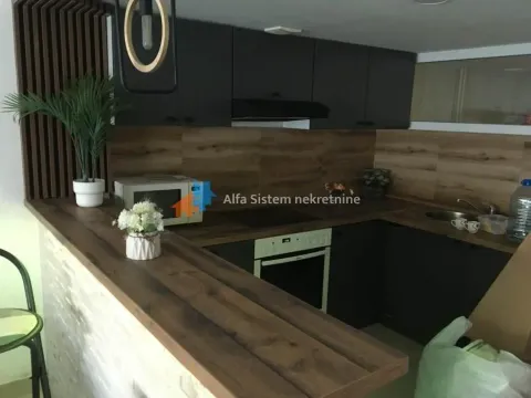 Modern kitchen with dark cabinets, wooden countertops, and a breakfast bar. - image 9