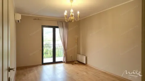 Prazna soba sa parketom i balkonskim vratima koja vode na terasu. - image 16