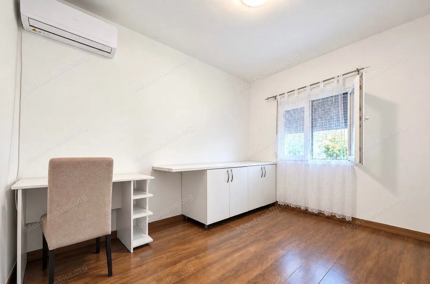 Bright room with a desk, a cabinet, and an air conditioning unit.
