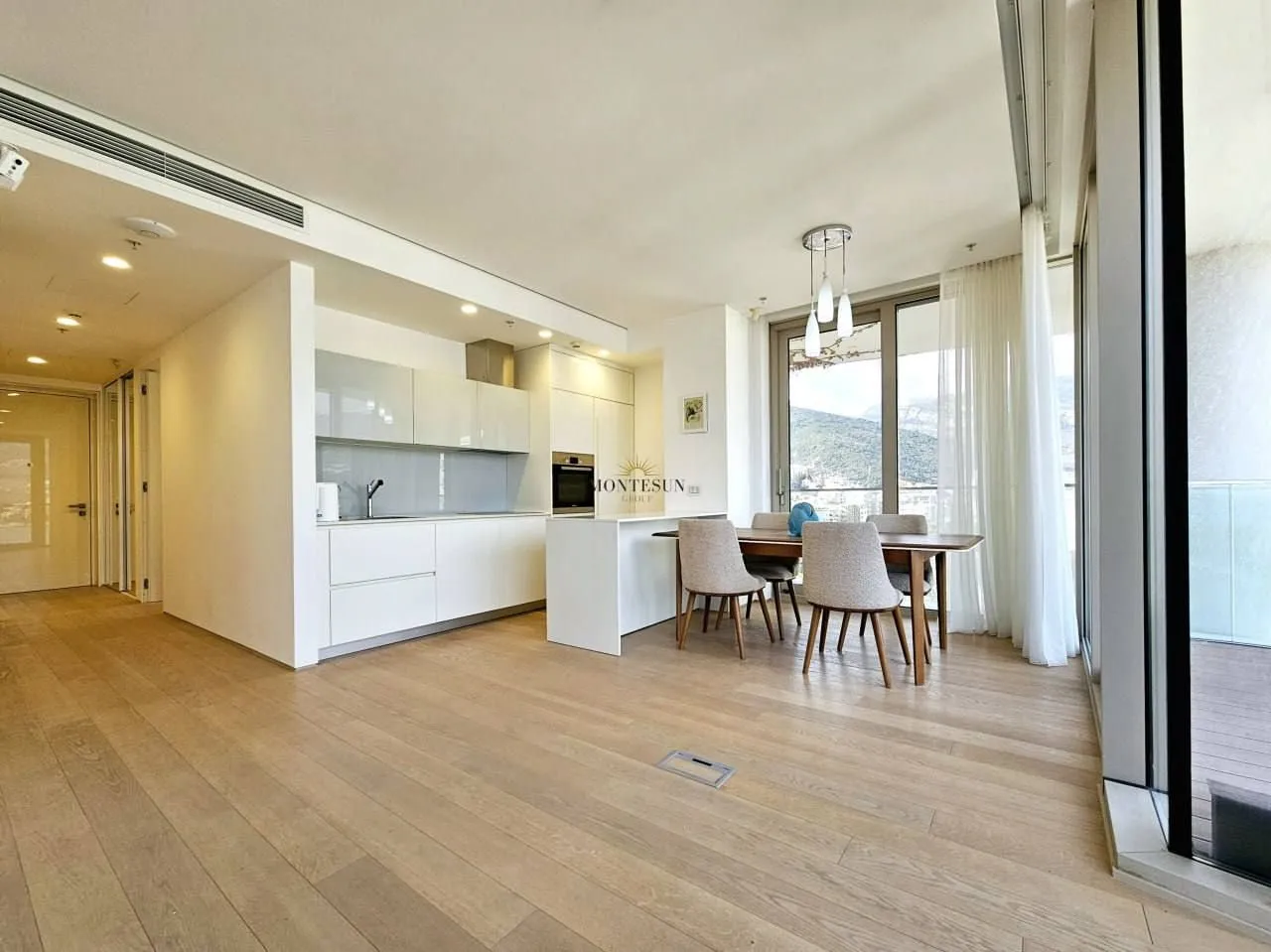Modern bright living room with dining area and built-in kitchen.