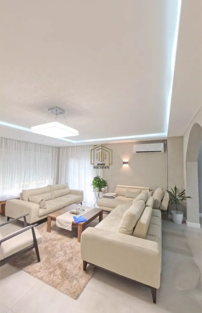 Spacious living room with a seating set and a wooden coffee table.