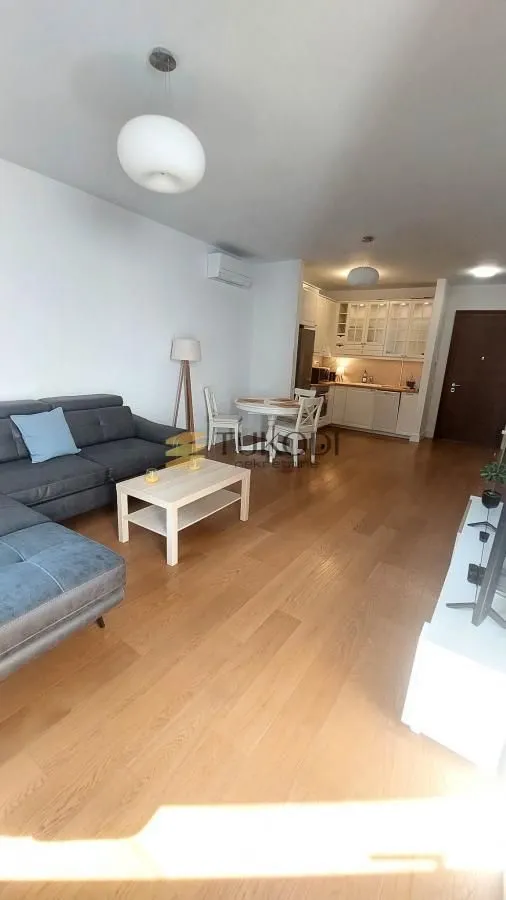 Living room with a sofa and dining area connected to the kitchen.
