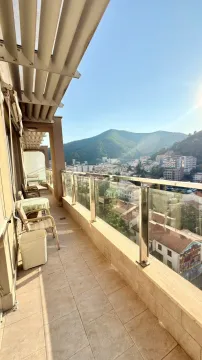 Long tiled balcony with outdoor seating and a view of the town and hills. - image 8