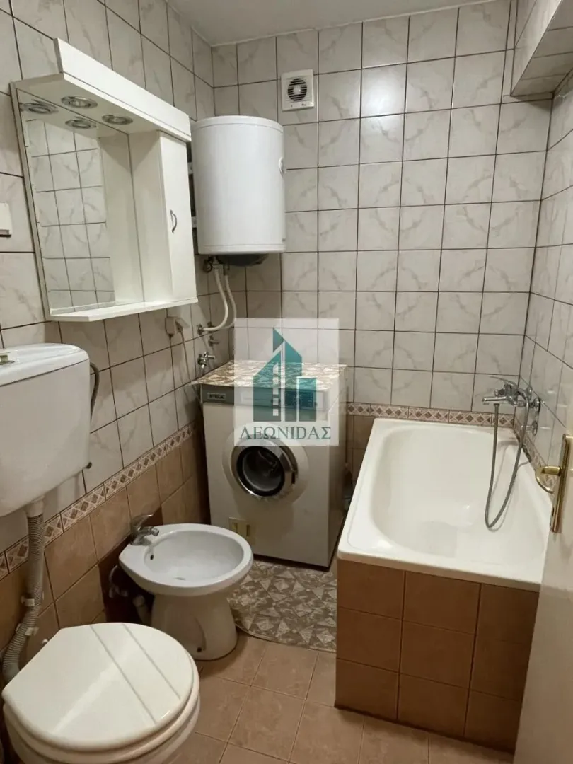 Bathroom equipped with a bathtub, washbasin, toilet, and washing machine.