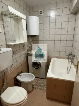 Bathroom equipped with a bathtub, washbasin, toilet, and washing machine. - image 8