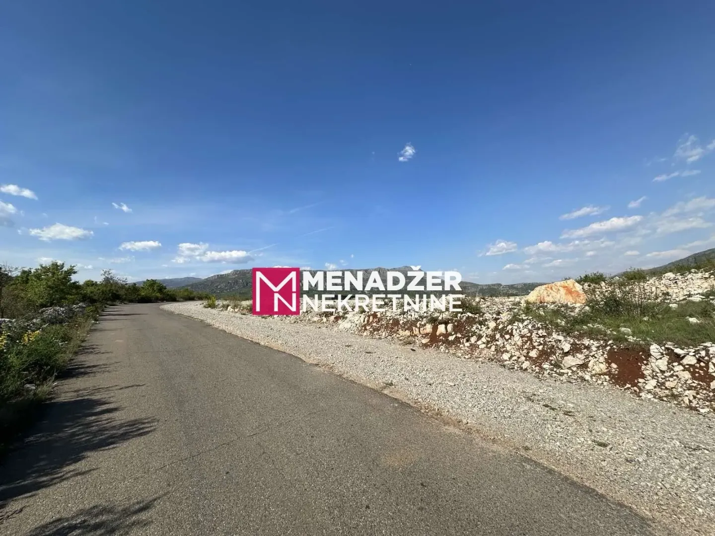 Asfaltni put pored zemljišta u prirodi.
