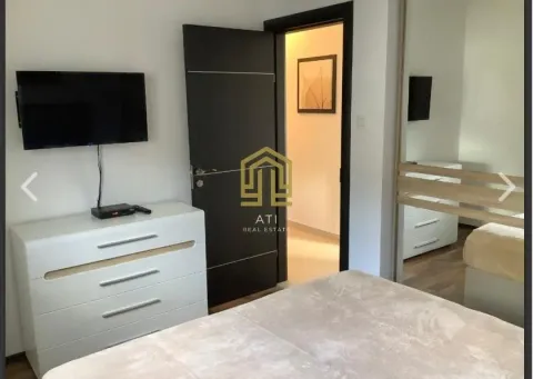 Namještena spavaća soba sa krevetom, komodom i televizorom na zidu. - image 6
