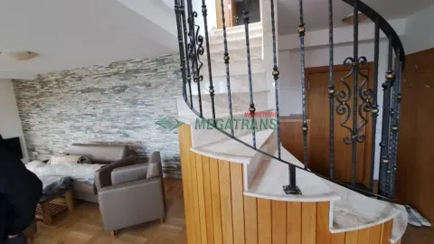 Living room with a spiral staircase and a decorative stone wall. - image 14