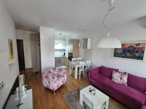 Svijetao dnevni boravak sa ljubičastom garniturom i kuhinjom u pozadini. - image 4
