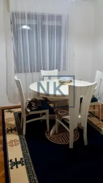 Trpezarijski sto sa bijelim stolicama i tepihom u prostoriji. - image 8