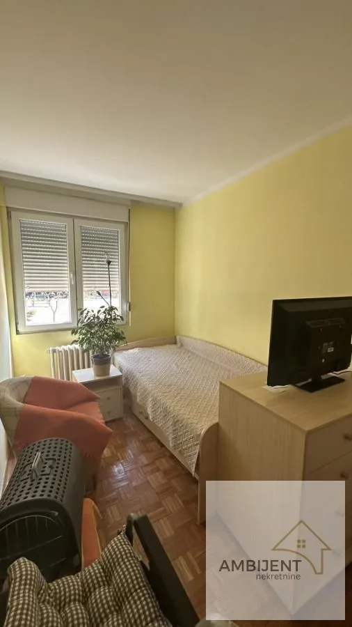 Smaller bedroom with a bed, dresser, and a window.
