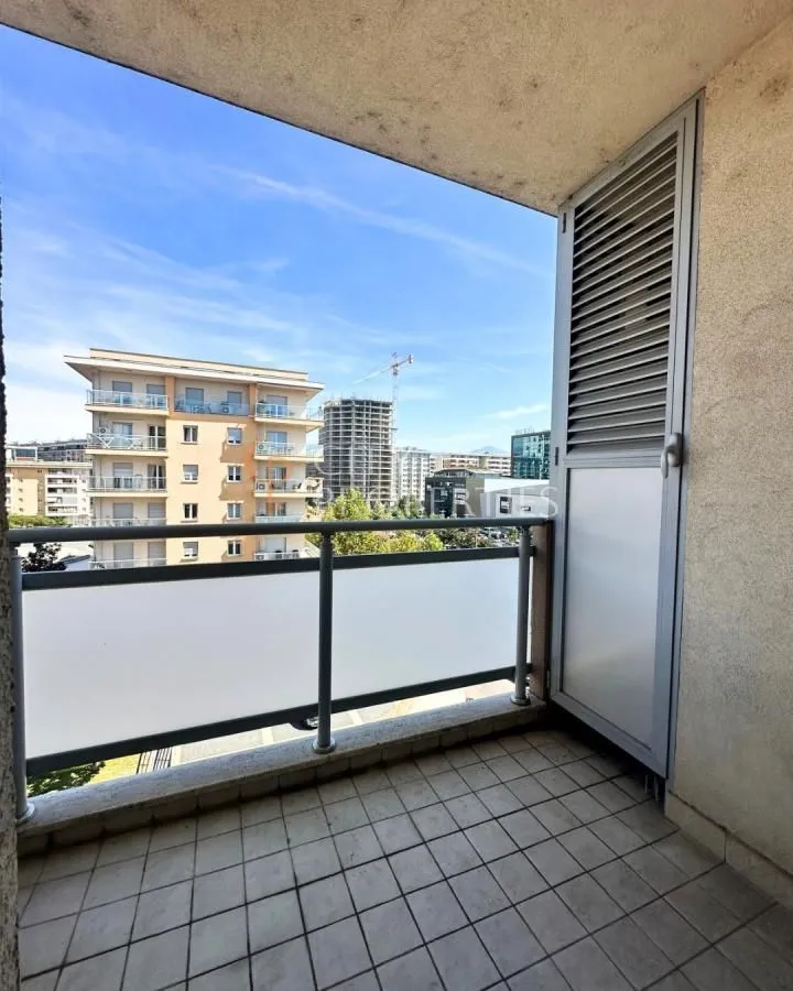 Manji popločani balkon sa pogledom na grad i okolne zgrade.