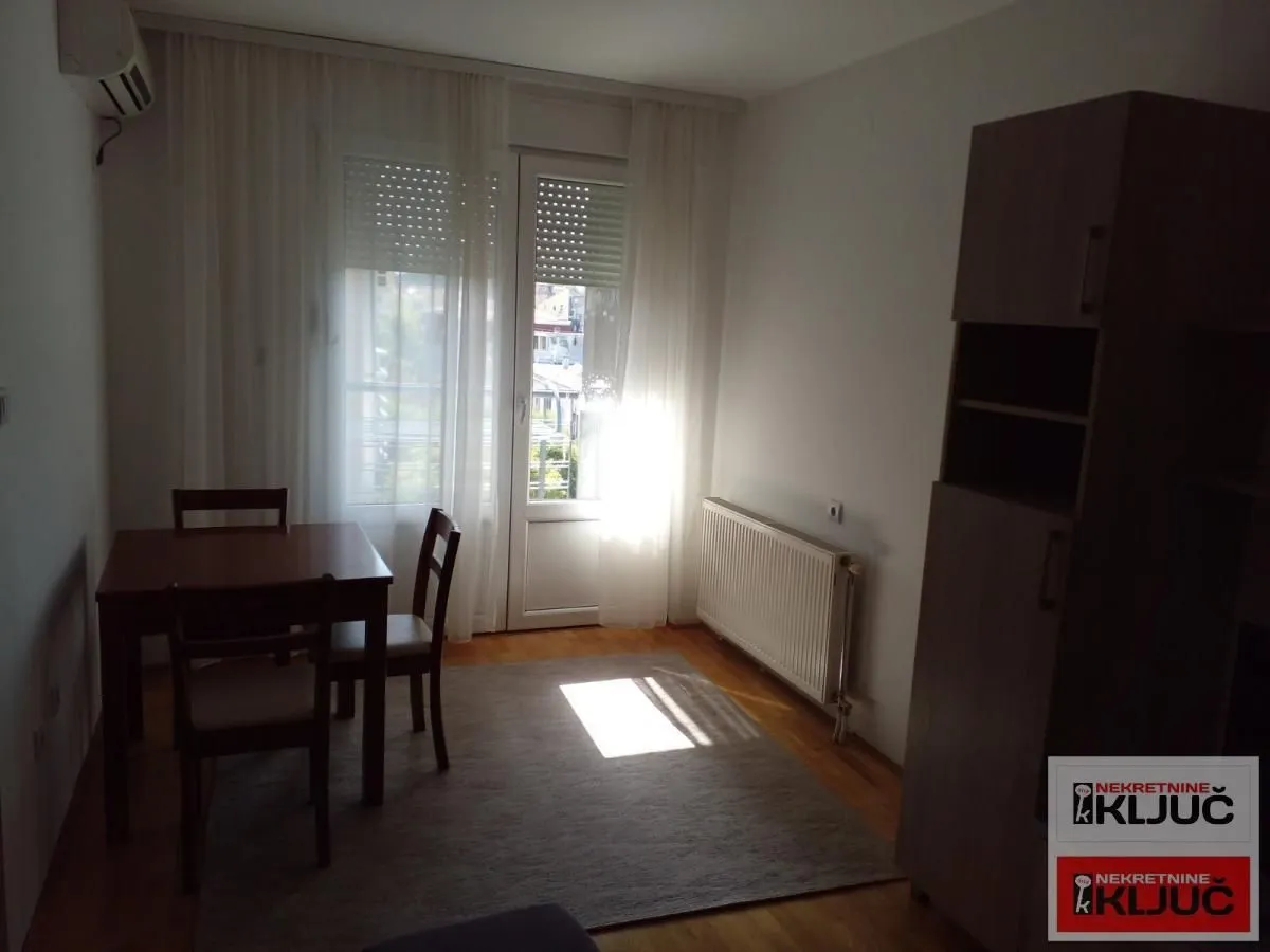 Dnevna soba sa trpezarijskim stolom i izlazom na terasu.