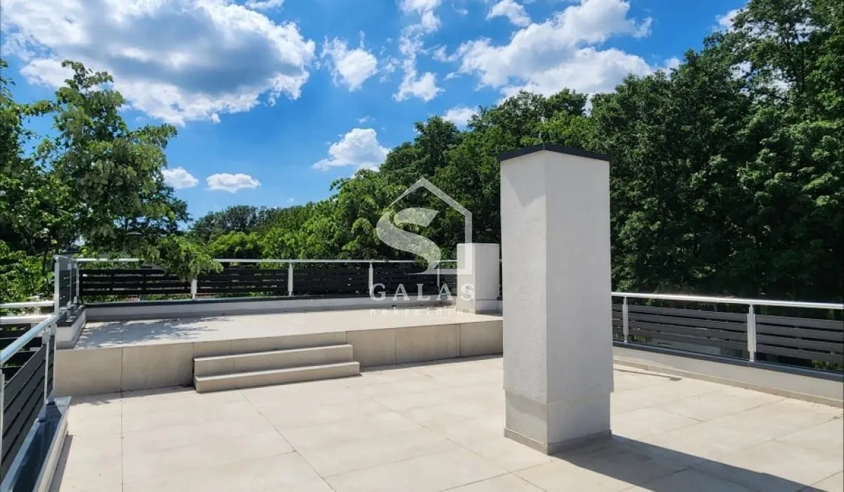 Spacious tiled terrace with a railing and a view of nature.