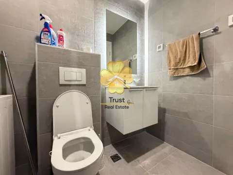 Modern bathroom with a sink, toilet, and grey tile finishes. - image 11